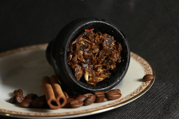 bowl with tobacco for hookah. berries on a black background