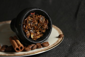 bowl with tobacco for hookah. berries on a black background