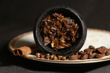 bowl with tobacco for hookah. berries on a black background