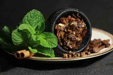 bowl with tobacco for hookah. berries on a black background