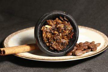 bowl with tobacco for hookah. berries on a black background