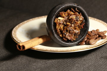 bowl with tobacco for hookah. fruits on a black background. smoke hookah