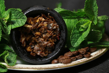 bowl with tobacco for hookah. berries on a black background