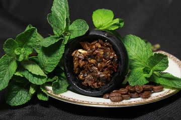 bowl with tobacco for hookah. fruits on a dark background. smoking hooka