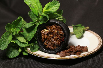 bowl with tobacco for hookah. berries on a black background