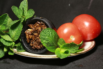 bowl with tobacco for hookah. fruits on a black background. smoke hookah