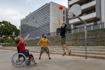 three boys, one of them in a wheelchair playing basketball