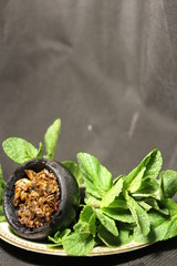 bowl with tobacco for hookah. fruits on a black background. smoke hookah