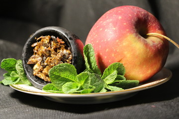 bowl with tobacco for hookah. berries on a black background