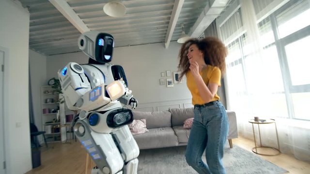 Young woman and droid dance together. Cyborg and human concept.