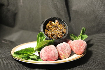 bowl with tobacco for hookah. fruits on a black background. smoke hookah