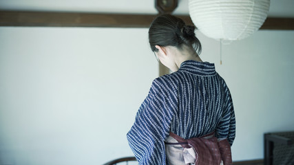 古民家で浴衣を着付ける女性の後ろ姿