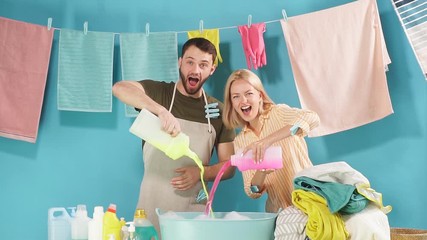 Crazy funny couple pouring different detergents in the bowl, preparation for washing by hands