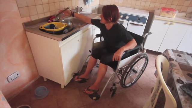disabled girl on wheel chair in everyday life in the kitchen