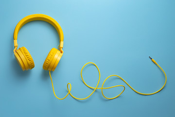 Yellow headphones on blue background. Music concept.