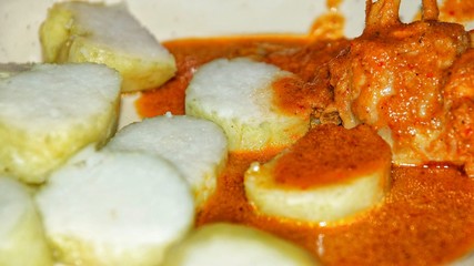 Chicken Rendang. Traditional Indonesian dish served during Eid al Fitr or Idul Fitri. Served with compressed rice cake or lontong. Selected focus. Close up.