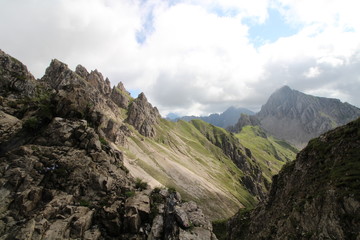 Bergsteigen in den österreichischen Alpen Blick auf grüne wiesen mit Felsen im Hintergrund