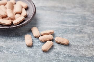 Rhodiola rosea. Golden root, rose root. Herbal pills with healthy medical plant. Healthy supplement on wooden background. Close up. 