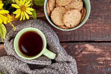 Knitted scarf with warm cup of tea