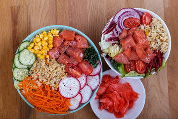 Raw fish, rice and healthy vegetables on wooden background