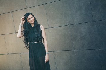 a beautiful brunette in a black dress and red shoes. Woman advertises accessories, clothes, shoes