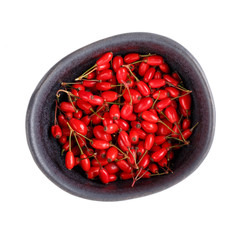 Ripe barberry berries in black bowl isolated on white. Top view.