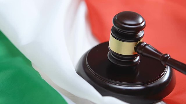Italian flag on background, judge hitting gavel, prohibition of deportation