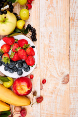 Flat lay of fruits over white wooden background, top view. Vegetarian, vegan, dieting, clean eating, weight loss ingredients.  Summer fruit food background. Copy space.