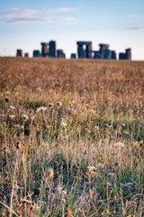 Sunrise at Stonehenge with golden wheat fields and clouds lit by warm sunlight northern England, UK