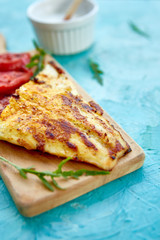 Grilled pike fillet with tomatoes on wooden board on blue background. Grilled seafood. Barbecue fish. Copy space. Healthy food.