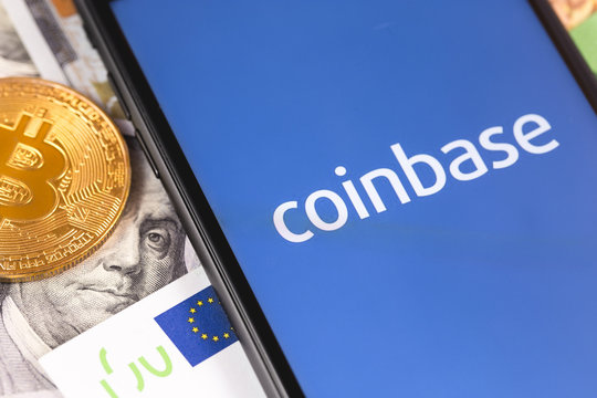 bitcoin, dollars, euro banknotes and smartphone with Coinbase logo on the screen. Coinbase is a digital currency exchange. Moscow, Russia - February 13, 2019