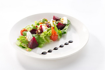 Salad with roasted beetroot, tomato, soft goat cheese isolated on white background