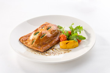 Puff pastry bun with spinach and tomato and lemon on the side isolated on white background
