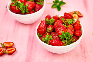 Ripe red strawberries on pink table, Strawberries in white bowls. Fresh strawberries. Beautiful strawberries. Diet food. Healthy, vegan. Top view. Flat lay.