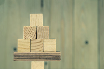 Christmas tree made of wooden cubes, on a wooden blurred background, space for text on the right, close-up, toned image