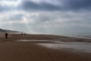 Fototapeta na wymiar Sunbeams breaking through storm clouds on the beaches of Cadiz