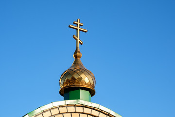Fototapeta na wymiar dome of the Orthodox Church with a cross against the blue sky