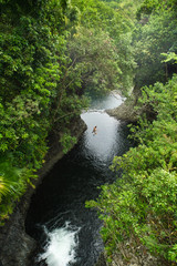 A brave man jumping from a cliff into a tropical river - 286667328