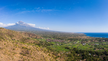 Fototapeta na wymiar Aerial panorama of Mt Agung volcano and the coastline in north Bali, near Amed, in Indonesia, Southeast Asia