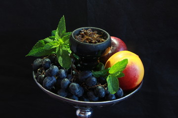 bowl with tobacco for hookah. berries on a black background