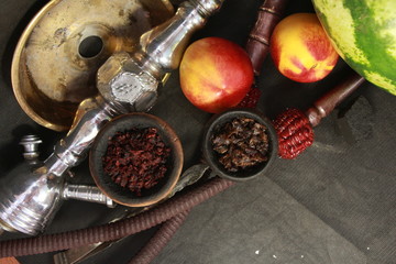 bowl with tobacco for hookah. fruits on a dark background. smoking nargile