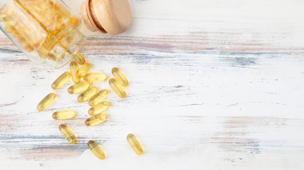 Top view of vitamin and pharmaceutical medicine pills, tablets and capsules in wooden spoon on pastel blue background. Dietary supplement healthcare product. Concept of health with copy space.