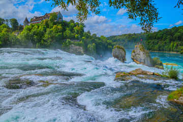 At the Rhine Falls in Switzerland. - There are much bigger waterfalls, but this "small" waterfall has something fascinating for many visitors because of the castle above and the forest around it.