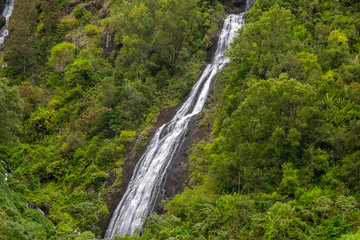 Waterfall on a green mountain at french island Reunion in the indian ocean