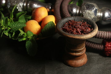 bowl with tobacco for hookah. berries on a black background