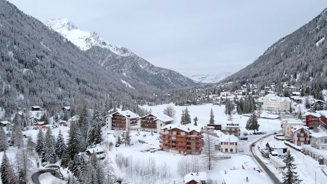 4K Ski resort winter sport in Europe aerial shot. Winter season in the alps on a cloudy day