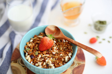 granola with strawberries in a plate on a white table