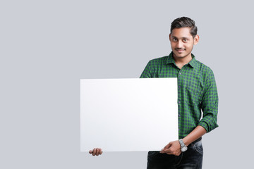 young indian guy holding blank poster