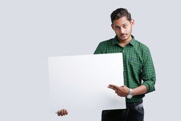young indian guy holding blank poster