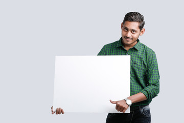 young indian guy holding blank poster